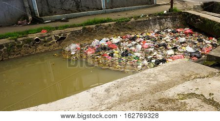 Mound of trash clogs a dirty river photo taken in Bogor Indonesia java