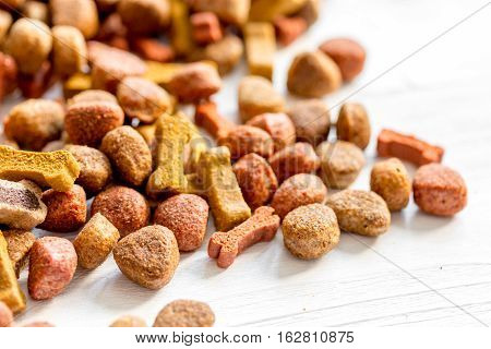 dry dog food in bulk on wooden background close up.