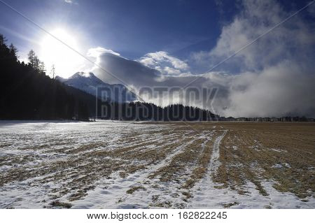 amazing landscape scenic view of Engadin valley in Switzerland Sils Maria village with snow on Alp mountains and frozen ground on a cold sunny winter day in tourism and holiday destination