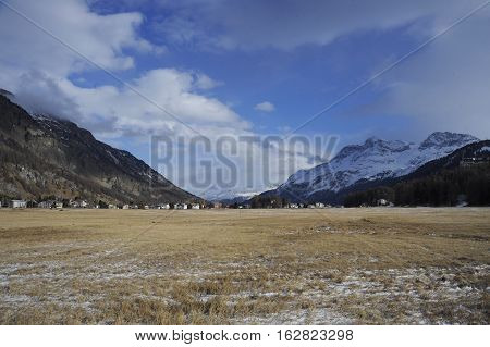 amazing landscape scenic view of Engadin valley in Switzerland Sils Maria village with snow on Alp mountains and frozen ground on a cold sunny winter day in tourism and holiday destination