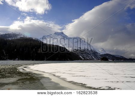 amazing landscape scenic view of Engadin valley in Switzerland Sils Maria village with snow on Alp mountains and frozen lake on a cold sunny winter day in tourism and holiday destination