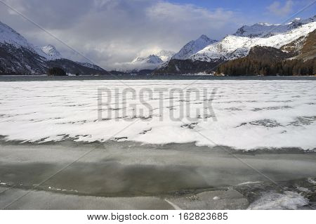 amazing landscape scenic view of Engadin valley in Switzerland Sils Maria village with snow on Alp mountains and frozen lake on a cold sunny winter day in tourism and holiday destination