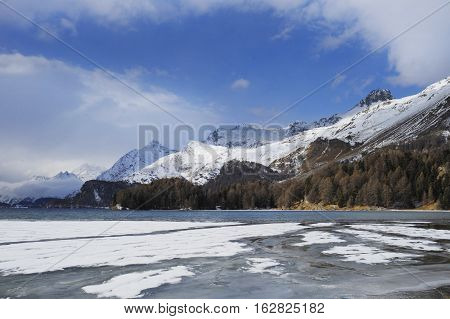 amazing landscape scenic view of Engadin valley in Switzerland Sils Maria village with snow on Alp mountains and frozen lake on a cold sunny winter day in tourism and holiday destination