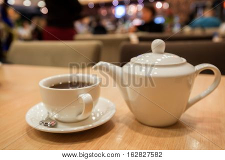 Teapot and cups are prepared for tea drinking in cafe