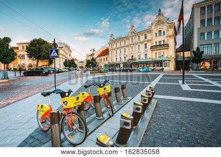 Vilnius, Lithuania  - July 8, 2016: Two Colorful Bicycles For Rent At The Municipal Bike Parking On Didzioji Street, The Ancient Showplace In Old Town. Radisson Blu Royal Astorija Hotel Behind In Summer, Blue Sky