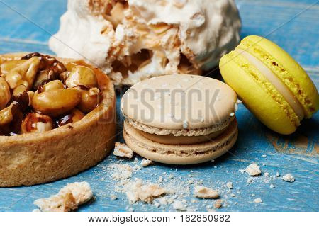 Sweet pecan cupcake, macaron and meringue on wooden table