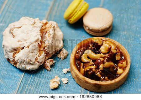 Sweet pecan cupcake, macaron and meringue on wooden table