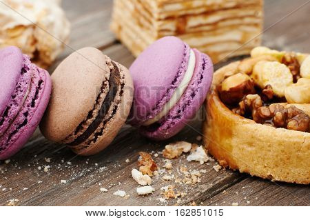 Sweet pecan cupcake, macaron and meringue on wooden table