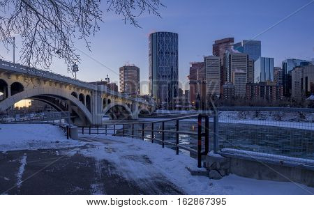 CALGARY, CANADA - DEC 17: Calgary's skyline at sunrise on a cold winter day on December 17, 2016 in Calgary, Alberta. Calgary is home to many oil companies. The Bow River is visible.
