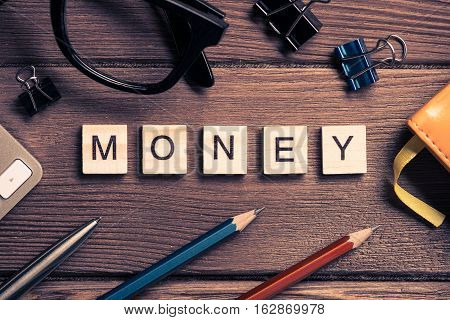 Workspace desk with keyboard office working stuff and wooden elements with the letters collected in the word money