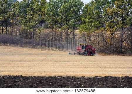Harvester is working in the field during harvest time.