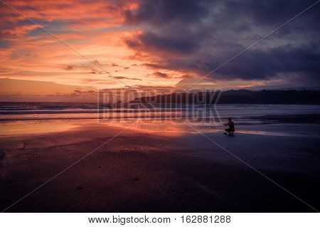 Sunset warm and cold. Girl backlit taking photo
