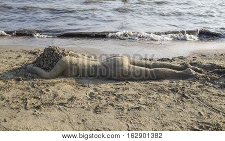 The girl from the sand. Fashioned rest on the sea sand girl.