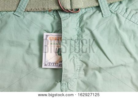 hundred dollar bill inside codpiece green pants closeup