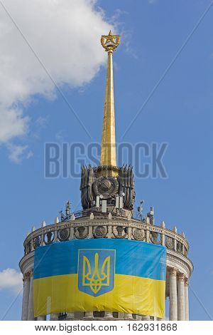 Ukrainian flag on the front of the building with the star which was built in the times of the USSR. Kiev Ukraine
