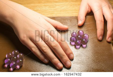 hands girl doing needlework of purple hydrogel beads