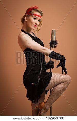 Pretty Actress In Black Retro Dress Singing With Microphone