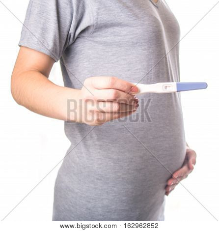 Girl with tummy holding pregnancy test. White isolated