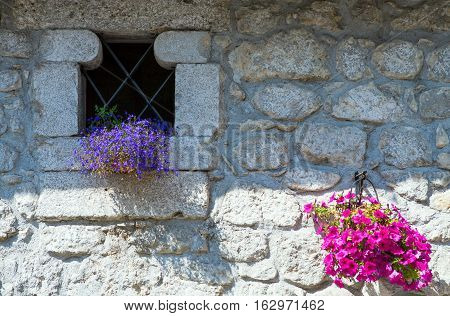 Italia Pescasseroli a little window and flowers on the facade of an old house