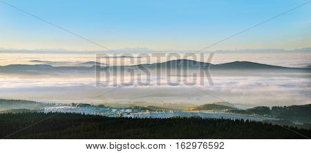 Panorama of the Alps from the tower Haidel in Bavaria. The magnificent panorama of the Alps. Villages and countryside in the fog lit by the morning sun.