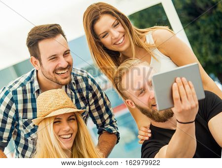 Friends faving fun and making a selfie outdoors.Summerholidays and happiness concept.