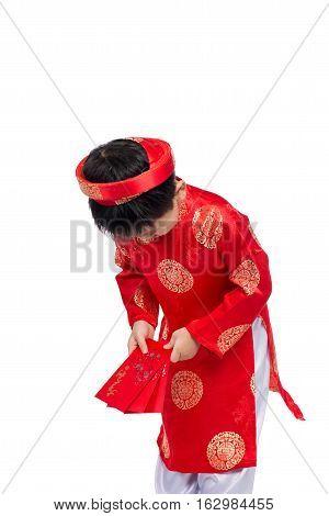 Little Vietnamese boy holding red envelops for Tet. The word mean double happiness. It is the gift in lunar new year or Tet Holiday on red isolate background.
