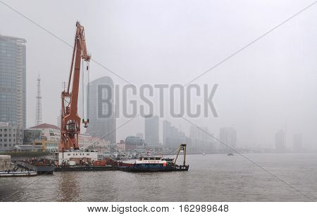 Shanghai China - April 20 2010: Air pollution in City Floating crane near the Bund during a polluted day Buildings are shrouded in smog.