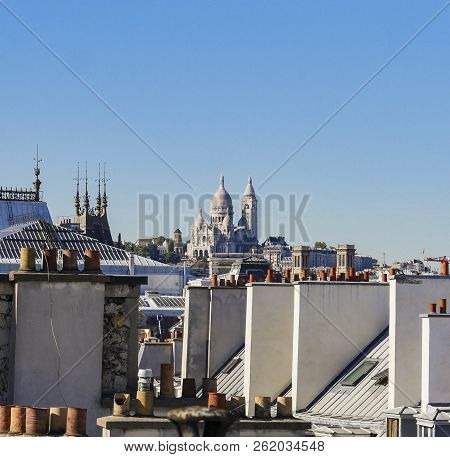 The Roofs Of Paris And Its Chimneys Under A Clouds Sky