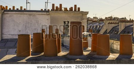 The Roofs Of Paris And Its Chimneys Under A Clouds Sky