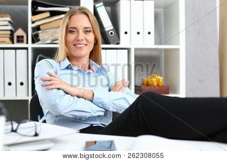 Business Woman Resting In The Office After A Working Day Throwing Her Feet On The Table Leaning Back