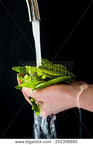 Women Hands Rincing Garden Peas With Runing Water. Healthy Food Concept.