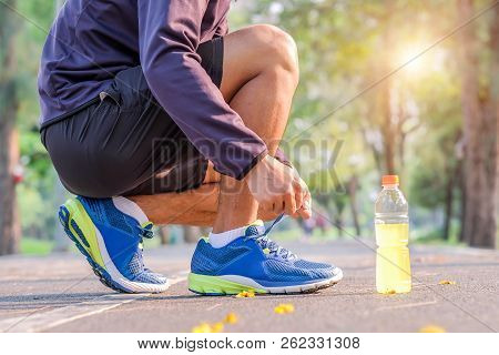 Young Athlete Man Tying Running Shoes In The Park Outdoor, Male Runner Ready For Jogging On The Road