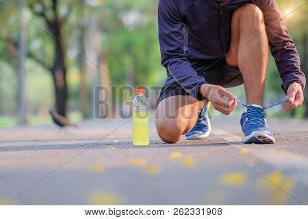 Young Athlete Man Tying Running Shoes In The Park Outdoor, Male Runner Ready For Jogging On The Road