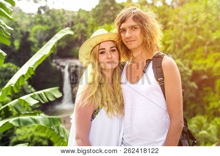 Young Honeymoon Couple In The Jungle On The Watefall Background. Bali Island.