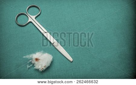 Scissors Along Cotton Blood Stained Isolated On Green Background, Conceptual Image