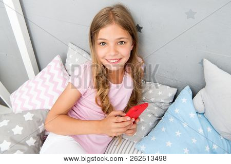 Activities For Pajama Party. Girl Kid Wear Pajama Hold Smartphone. Child In Pajama Hold Smartphone. 