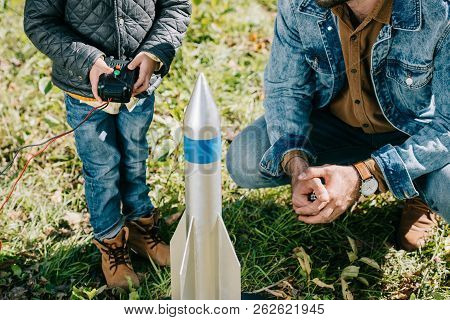 Cropped Shot Of Father And Little Son Launching Model Rocket Outdoor