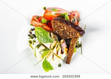 Salad Of Red Ripe Tomatoes With Green Parmesan Cheese With Black Bread And Bran On White Plate Isola