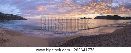 Panoramic View On Beautiful Pastel Pink Orange And Golden Sunset Clouds And Waves At Sea Shore Agios