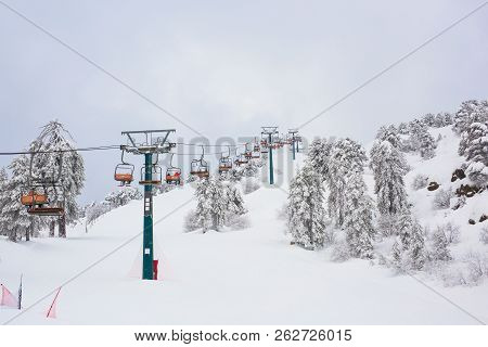 Cyprus Ski Lifts And Cable Cars Going Up The Mountain Bringing Snowboarders To Ski Slopes.