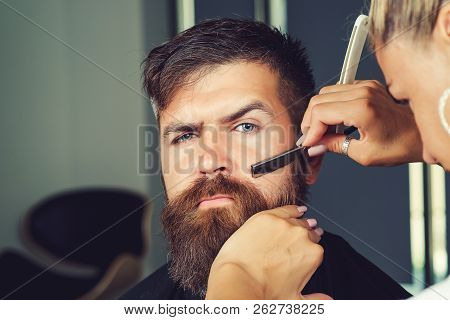 Barber Woman Shaving Client's Beard In Barbershop Or Beaty Salon. Portrait Of Male Client Shaving Hi