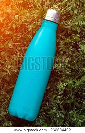 Stainless Thermos Water Bottle, Matte Light Blue Color. Mockup Isolated On Green Grass Background Wi