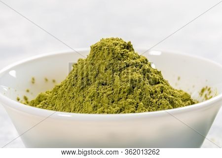 Close-up White Bowl Full Of Green Japanese Matcha Tea Powder On White Background. Matcha Tea Leaves 