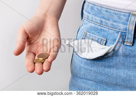 Woman Showing Empty Pockets And Few Coins In Hand . Bancruptcy Concept.