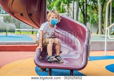 Funny Cute Happy Baby In Medical Mask Playing On The Playground. The Emotion Of Happiness, Fun, Joy 