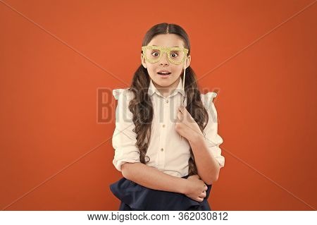 School Party Concept. What Does It Mean Being Smart. Little Smart Schoolgirl On Orange Background. C