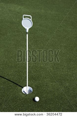 Golf Ball And Hole On A Field