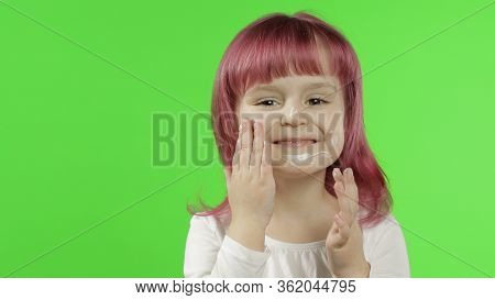 Beauty Caucasian Child Girl Model With Pink Hair Using Cream. Close Up. Puts Cream On Her Face Touch