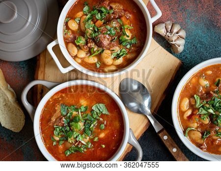 Bean Soup With Meat And Vegetables Served On A Rustic Board With Garlic. Traditional Balkan Soup Or 