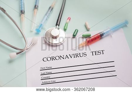 A Syringe With A Blood Test And A Stethophonendoscope With A Patient Questionnaire And Tablets For A